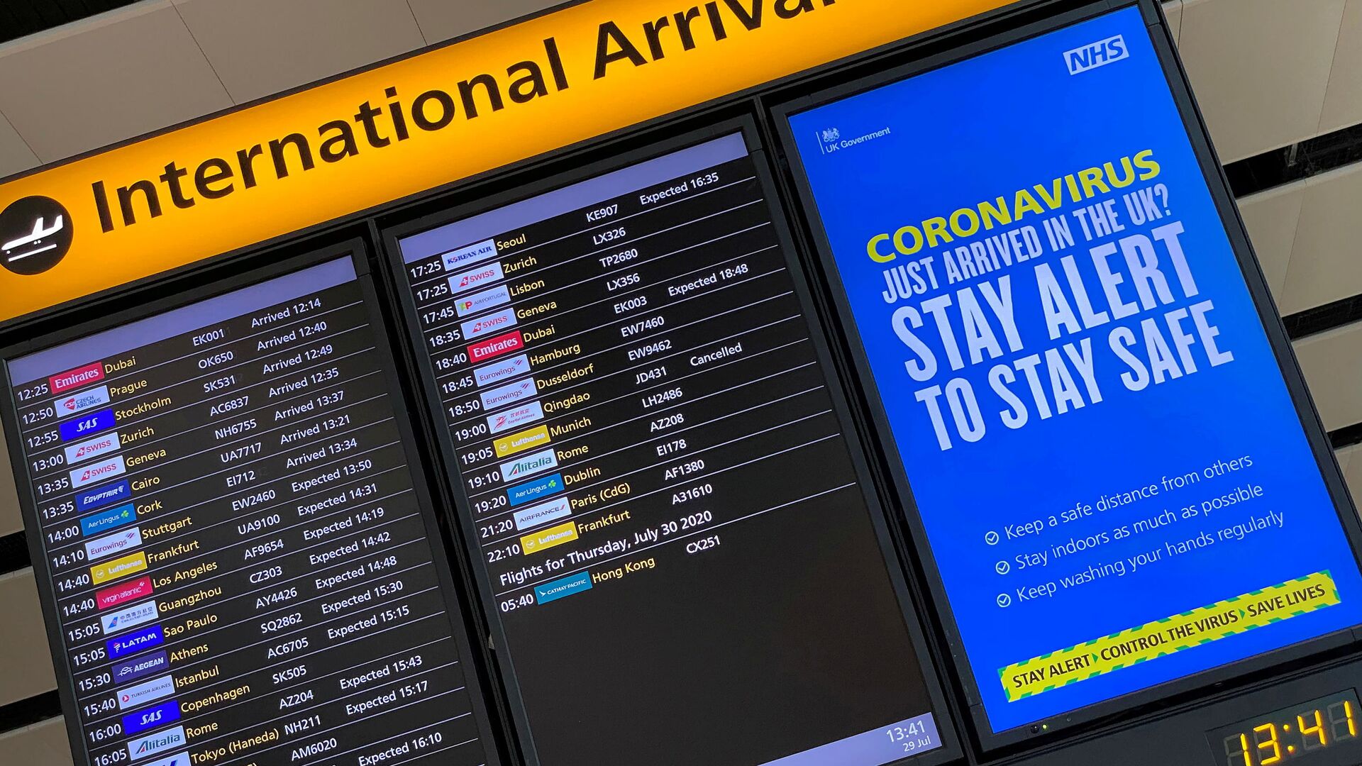 A public health campaign message is displayed on an arrivals information board at Heathrow Airport, following the outbreak of the coronavirus disease (COVID-19), London, Britain, July 29, 2020 - Sputnik International, 1920, 20.01.2022