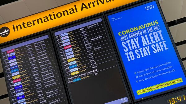 A public health campaign message is displayed on an arrivals information board at Heathrow Airport, following the outbreak of the coronavirus disease (COVID-19), London, Britain, July 29, 2020 - Sputnik International