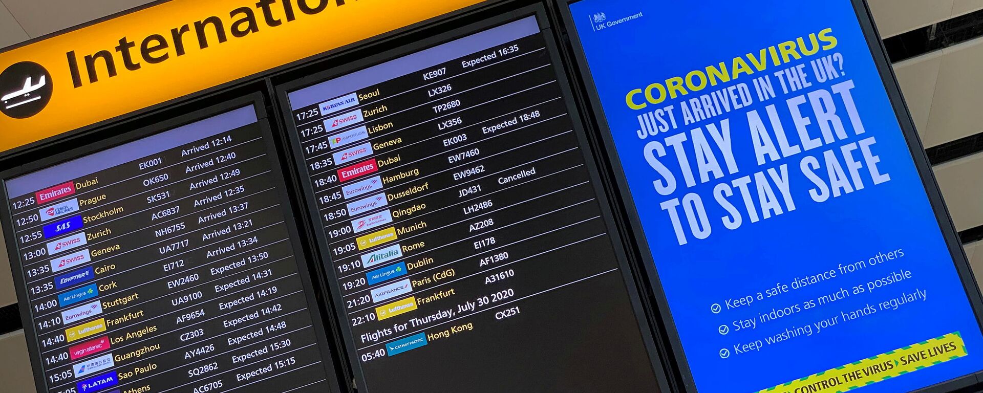 A public health campaign message is displayed on an arrivals information board at Heathrow Airport, following the outbreak of the coronavirus disease (COVID-19), London, Britain, July 29, 2020 - Sputnik International, 1920, 29.11.2021