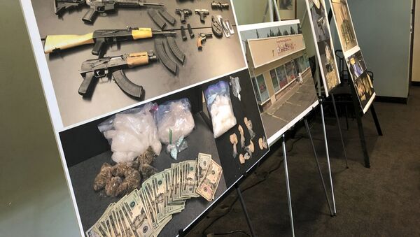 Photos of guns, drugs, and money are displayed at a press conference in Portland, Oregon in 2019 - Sputnik International