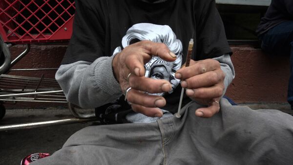 A drug addict prepares a needle to inject himself with heroin in front of a church in the Skid Row area of Los Angeles.  - Sputnik International