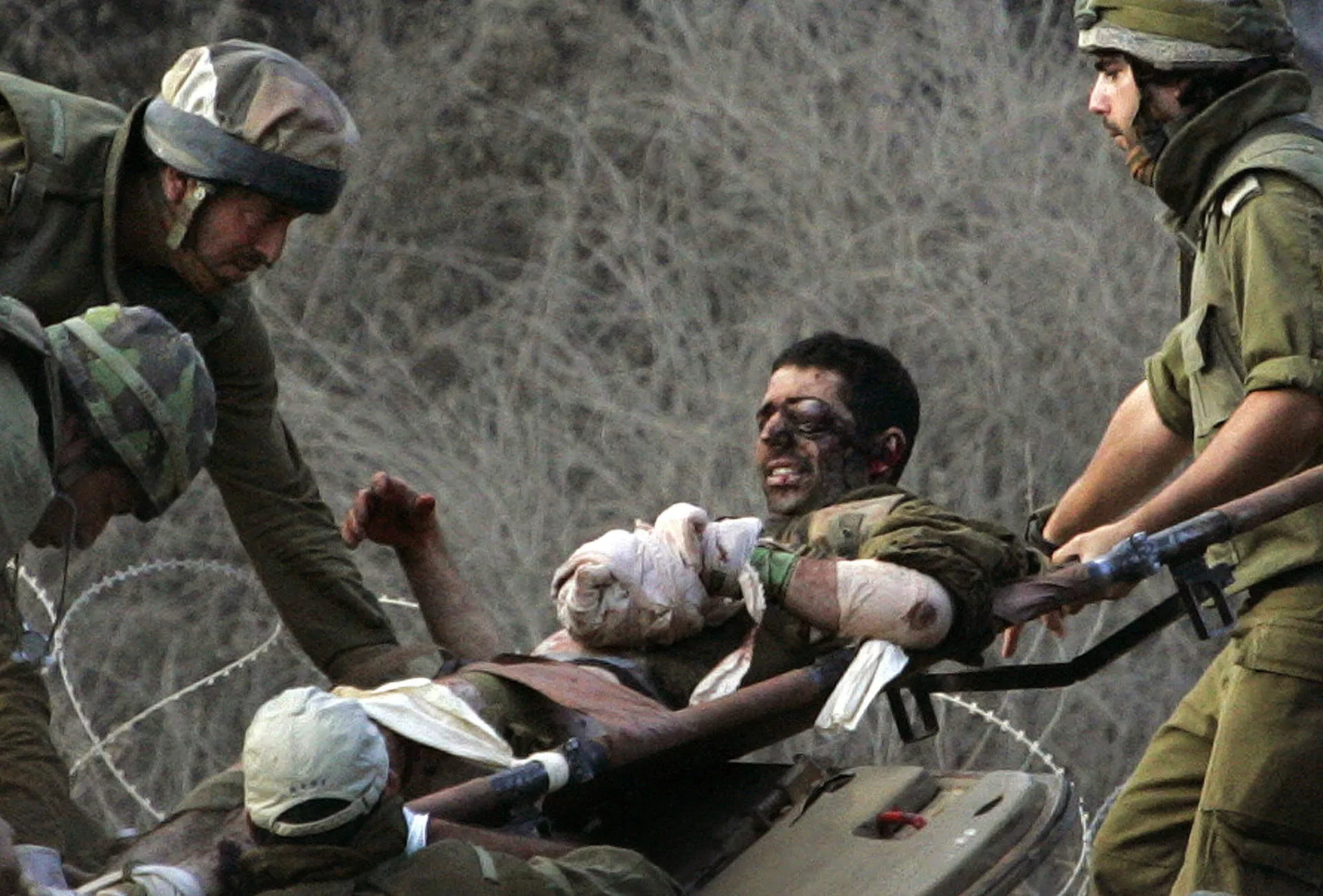 En esta foto de archivo del 9 de agosto de 2006, soldados israelíes llevan a un camarada herido desde un vehículo blindado de transporte de personal hasta una ambulancia que los espera tras cruzar la frontera desde el Líbano hacia el norte de Israel. - Sputnik Internacional, 1920, 28.09.2024