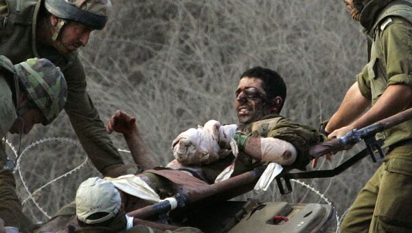Israeli soldiers carry a wounded comrade off an armored personnel carrier to a waiting ambulance after crossing the border from Lebanon into northern Israel, in this Aug. 9, 2006 file photo.  - Sputnik International