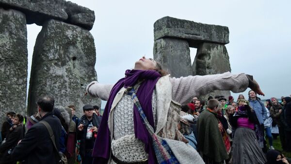 A person looks up as she attends the celebration of the Summer Solstice at Stonehenge ancient stone circle, despite official events being cancelled amid the spread of the coronavirus disease (COVID-19), near Amesbury, Britain, June 21, 2021 - Sputnik International