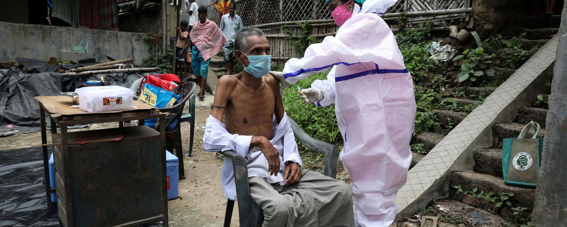 Motiar Rahman, a villager, receives a dose of COVISHIELD vaccine, a coronavirus disease (COVID-19) vaccine manufactured by Serum Institute of India, during a door-to-door vaccination and testing drive at Uttar Batora Island in Howrah district in West Bengal state, India, June 21, 2021. - Sputnik International, 1920, 20.09.2021