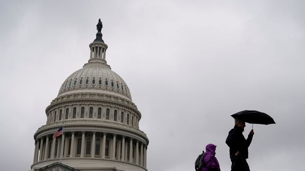 People walk past the Capitol Dome ahead of an expected vote in the impeachment trial of U.S. President Donald Trump on Capitol Hill in Washington, U.S., February 5, 2020. - Sputnik International