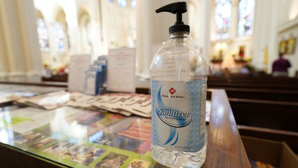 A bottle of hand sanitizer stands near an entrance to Cathedral Basilica of the Immaculate Conception, where Christmas services were being held Thursday, Dec. 24, 2020, in Denver. - Sputnik International