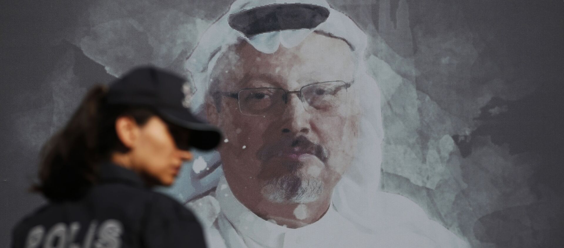 In this Wednesday, Oct. 2, 2019 file photo, a Turkish police officer walks past a picture of slain Saudi journalist Jamal Khashoggi prior to a ceremony, near the Saudi Arabia consulate in Istanbul, marking the one-year anniversary of his death. - Sputnik International, 1920, 03.08.2021