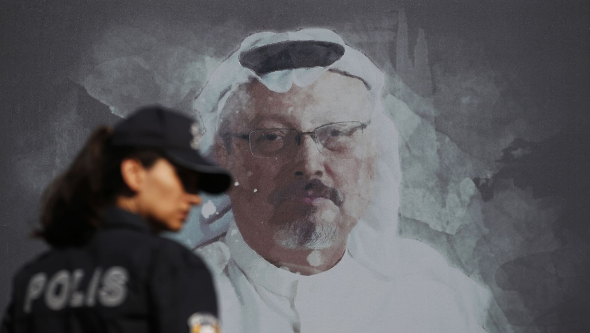 In this Wednesday, Oct. 2, 2019 file photo, a Turkish police officer walks past a picture of slain Saudi journalist Jamal Khashoggi prior to a ceremony, near the Saudi Arabia consulate in Istanbul, marking the one-year anniversary of his death. - Sputnik International, 1920, 23.06.2021