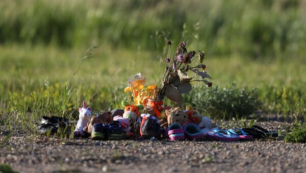 Shoes, stuffed animals and other offerings are seen at the site of the former Brandon Indian Residential School where researchers, partnered with the Sioux Valley Dakota Nation, located 104 potential graves in Brandon, Manitoba, Canada, June 12, 2021.  - Sputnik International
