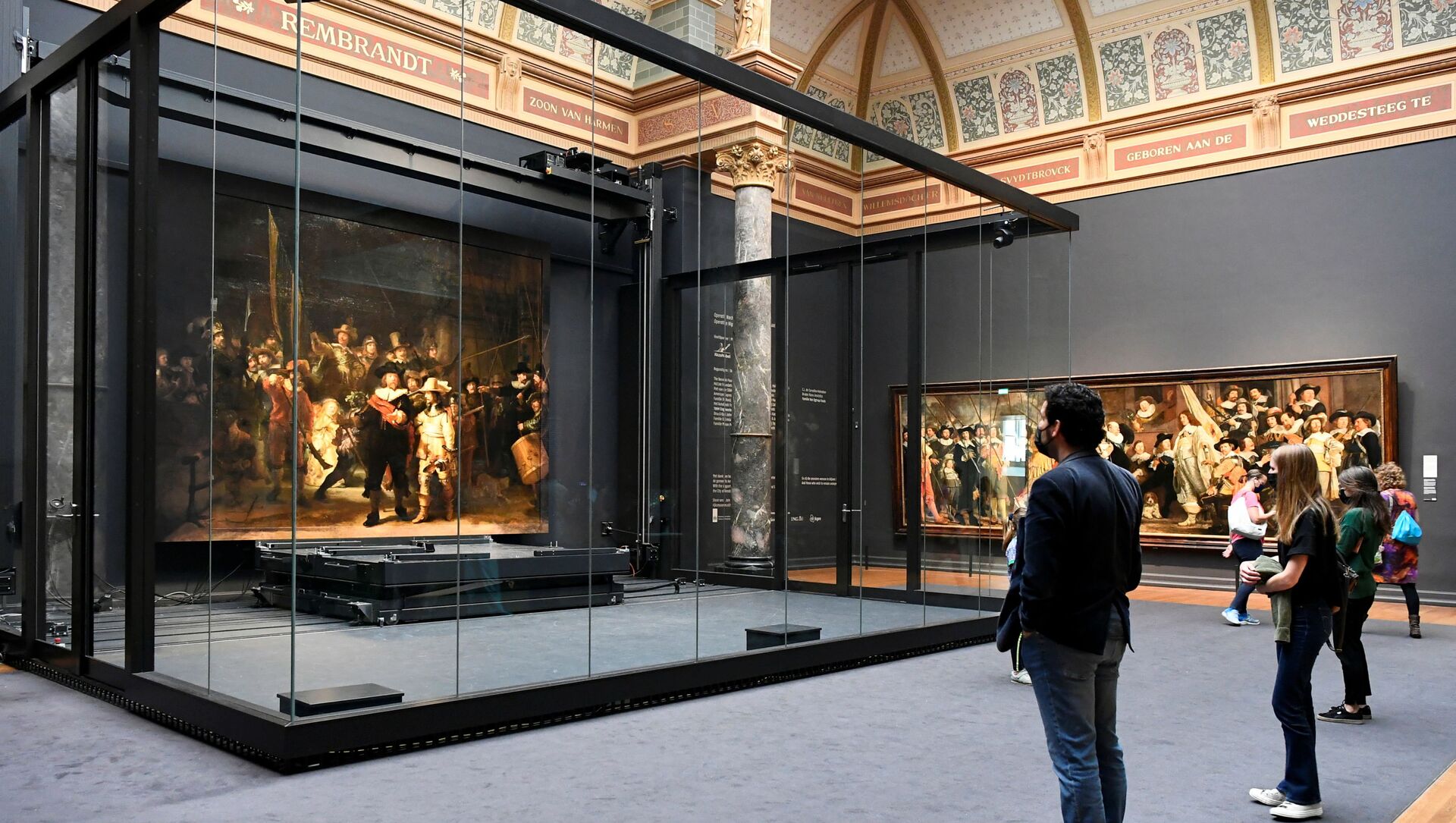 Poeple look at Rembrandt's famed Night Watch, which is back on display in what researchers say in its original size, with missing parts temporarily restored in an exhibition aided by artificial intelligence, at Rijksmuseum in Amsterdam, Netherlands June 23, 2021.  - Sputnik International, 1920, 25.06.2021