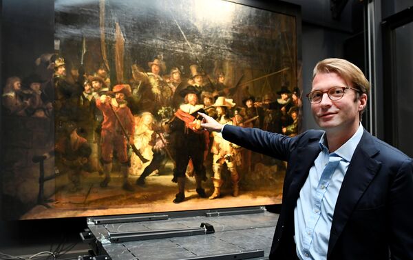 Museum director Taco Dibbits points to Rembrandt's famed Night Watch, which is back on display in what researchers say in its original size, with missing parts temporarily restored in an exhibition aided by artificial intelligence, at Rijksmuseum in Amsterdam, Netherlands June 23, 2021. - Sputnik International