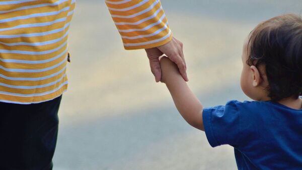 A parent holding hands with a child - Sputnik International