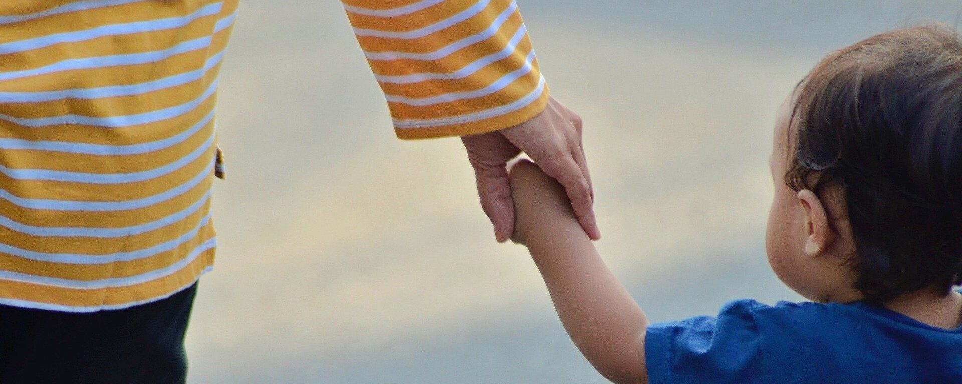 A parent holding hands with a child - Sputnik International, 1920, 25.04.2022