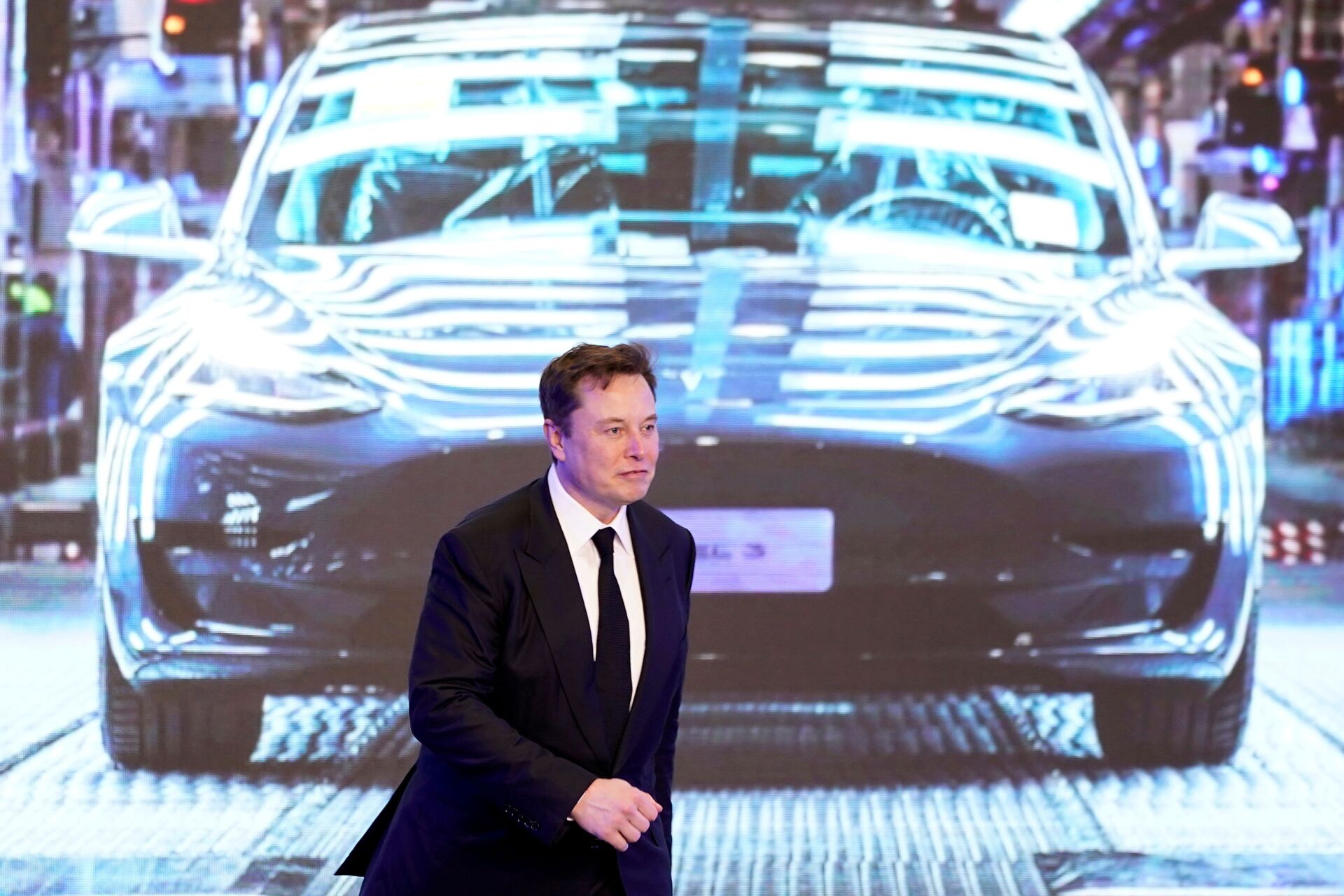 Tesla Inc CEO Elon Musk walks next to a screen showing an image of Tesla Model 3 car during an opening ceremony for Tesla China-made Model Y program in Shanghai, China January 7, 2020. - Sputnik International, 1920, 07.09.2021