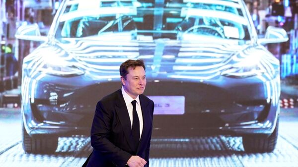 Tesla Inc CEO Elon Musk walks next to a screen showing an image of Tesla Model 3 car during an opening ceremony for Tesla China-made Model Y program in Shanghai, China January 7, 2020. - Sputnik International