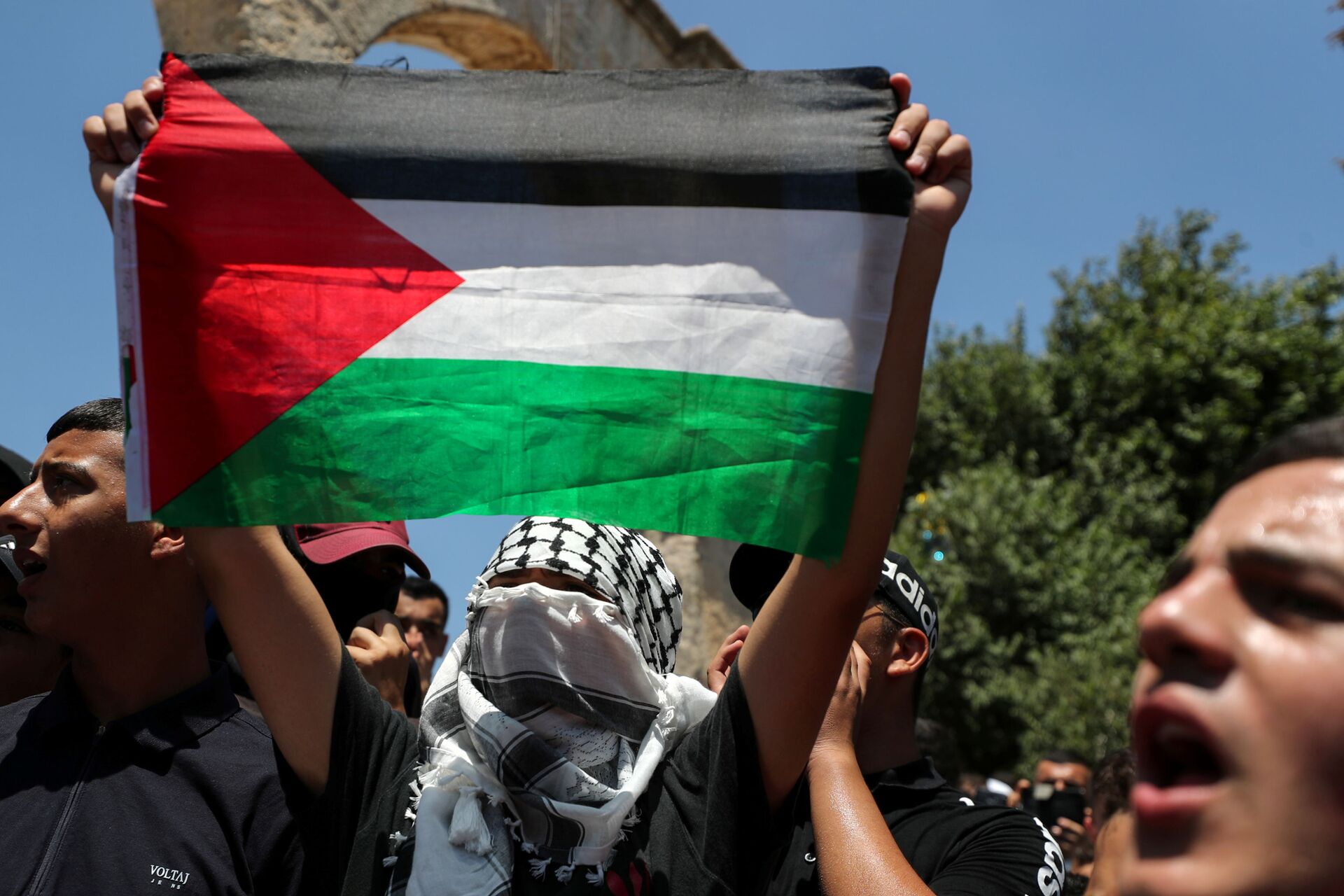 A demonstrator holds a Palestinian flag during a protest over the death of Nizar Banat, at the compound that houses Al-Aqsa Mosque, known to Muslims as Noble Sanctuary and to Jews as Temple Mount, in Jerusalem's Old City, June 25, 2021. - Sputnik International, 1920, 21.01.2022