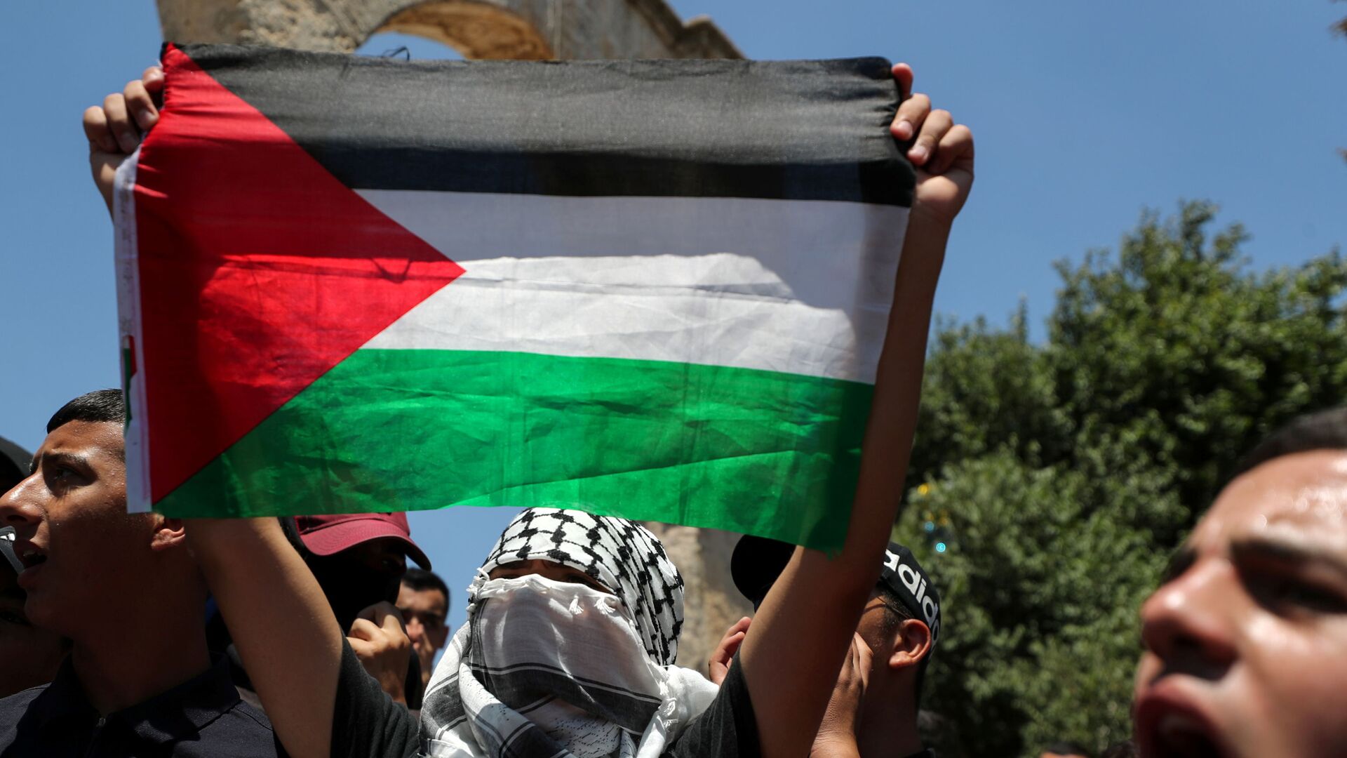 A demonstrator holds a Palestinian flag during a protest over the death of Nizar Banat, at the compound that houses Al-Aqsa Mosque, known to Muslims as Noble Sanctuary and to Jews as Temple Mount, in Jerusalem's Old City, June 25, 2021. - Sputnik International, 1920, 29.06.2021