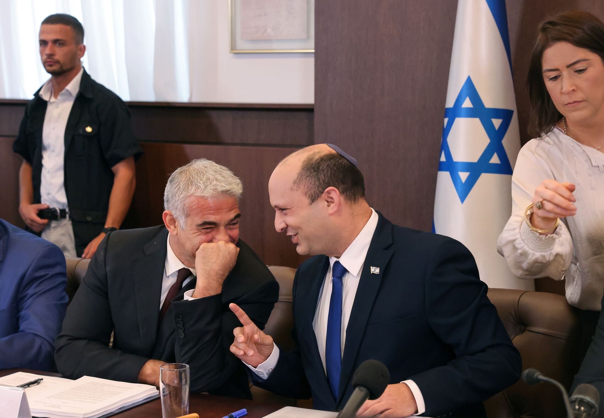 Israeli Prime Minister Naftali Bennett shares a joke with alternate Prime Minister and Foreign Minister Yair Lapid during the first weekly cabinet meeting of their new government in Jerusalem June 20, 2021. - Sputnik International, 1920, 07.09.2021