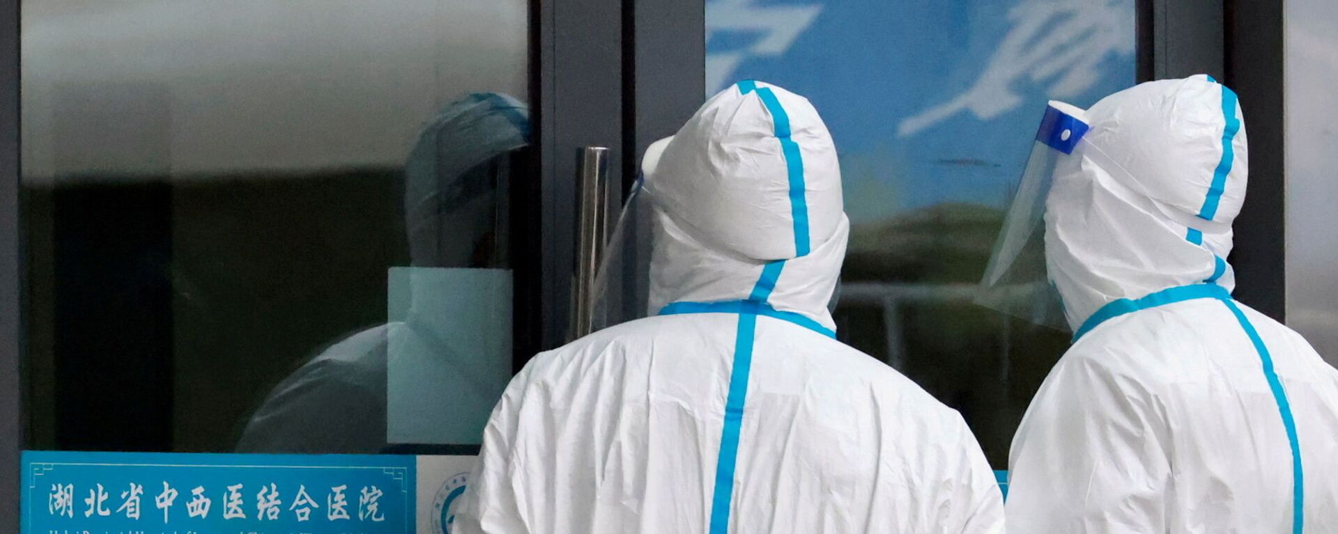 Staff members in protective suits stand at Hubei Provincial Hospital of Integrated Chinese and Western Medicine where members of the World Health Organisation (WHO) team tasked with investigating the origins of the coronavirus disease (COVID-19) are visiting, in Wuhan, Hubei province, China, 29 January 2021. - Sputnik International, 1920, 27.08.2021