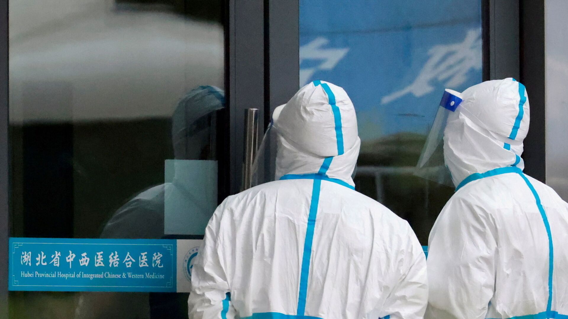 Staff members in protective suits stand at Hubei Provincial Hospital of Integrated Chinese and Western Medicine where members of the World Health Organisation (WHO) team tasked with investigating the origins of the coronavirus disease (COVID-19) are visiting, in Wuhan, Hubei province, China, 29 January 2021. - Sputnik International, 1920, 27.08.2021
