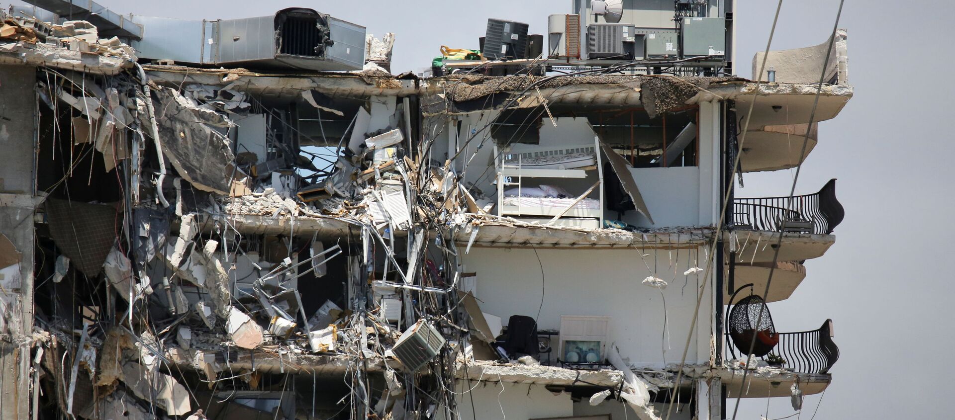 A view of a partially collapsed residential building as the emergency crews continue search and rescue operations for survivors, in Surfside, near Miami Beach, Florida, U.S. June 27, 2021 - Sputnik International, 1920, 28.06.2021