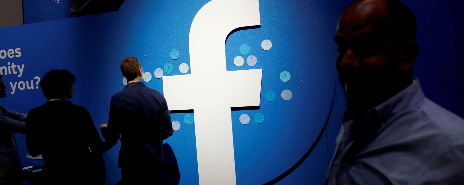 Attendees walk past a Facebook logo during Facebook Inc's F8 developers conference in San Jose - Sputnik International, 1920, 15.09.2021