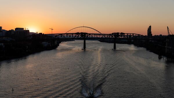 The sun sets as a boat travels down the Willamette River during a heat wave in Portland, Oregon, U.S. June 27, 2021.  - Sputnik International