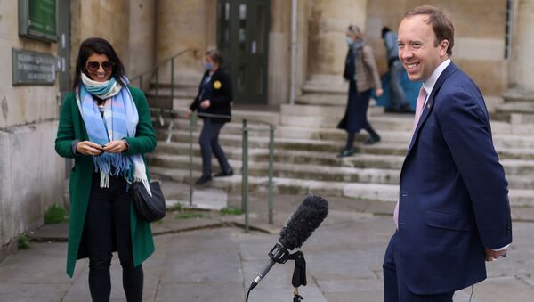 Britain's Health Secretary Matt Hancock smiles during a television interview as his aide Gina Coladangelo looks on, outside BBC's Broadcasting House in London - Sputnik International