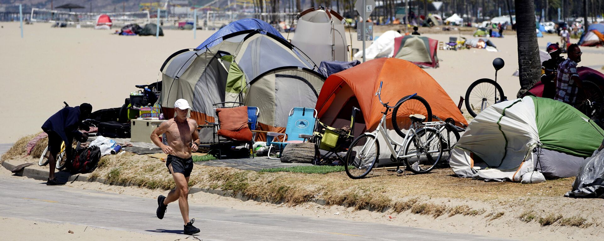 In this June 8, 2021, file photo, a jogger walks past a homeless encampment in the Venice Beach section of Los Angeles In this June 8, 2021, file photo, a jogger walks past a homeless encampment in the Venice Beach section of Los Angeles - Sputnik International, 1920, 12.12.2022