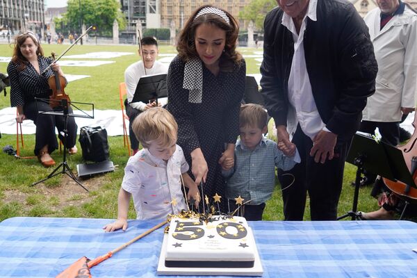 Stella Moris with their children cuts a birthday cake during a picnic in Parliament Square with her children.  - Sputnik International