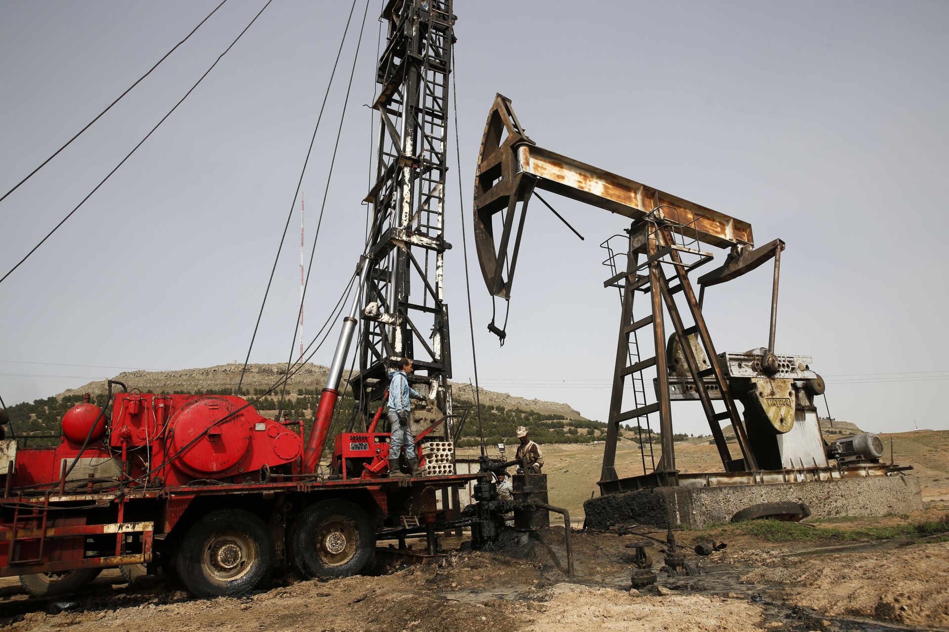 This March 27, 2018 file photo shows Syrian workers fixing pipes of an oil well at an oil field controlled by a U.S-backed Kurdish group, in Rmeilan, Hassakeh province, Syria. - Sputnik International, 1920, 07.09.2021