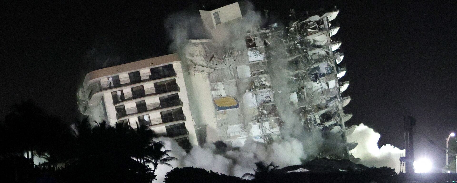 The remaining part of the partially collapsed 12-story Champlain Towers South condo building falls with a controlled demolition on 4 July 2021 in Surfside, Florida. The decision by officials to bring the rest of the building down was brought on by the approach of Tropical Storm Elsa and fears that the structure might come down in an uncontrolled fashion. Over one hundred people are missing as the search-and-rescue effort continues. - Sputnik International, 1920, 04.08.2021