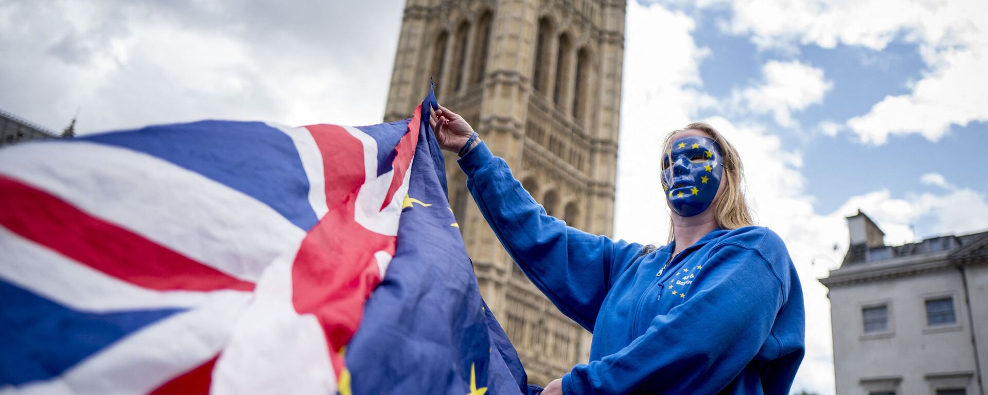 A Pro-European Union protester holds Union and European flags in front of the Victoria Tower at The Palace of Westminster in central London on September 13, 2017, ahead of a rally to warn about the terms of Brexit, by EU nationals in Britain and UK nationals in Europe - Sputnik International, 1920, 05.07.2021
