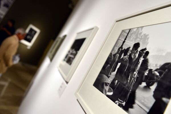 A visitor looks at pictures by French photographer Robert Doisneau during the Paris en Liberte exhibition held at the Palazzo delle Esposizioni in Rome on 28 September 2012.  - Sputnik International