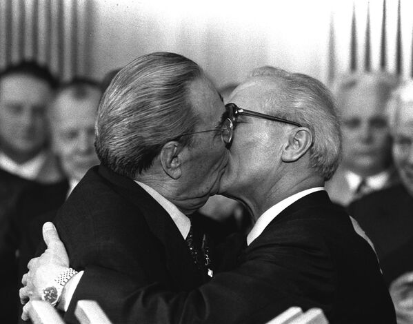 Soviet General Secretary Leonid Brezhnev and East German leader Erich Honecker exchange kisses after Brezhnev was honoured with the title Hero of the German Democratic Republic and the Karl Marx Medal, 1979. - Sputnik International