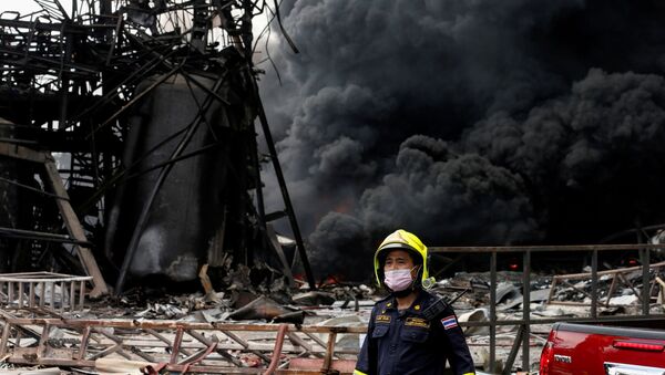 Emergency personnel looks on as smoke rises from a plastic factory after an explosion in Samut Prakan, outside Bangkok, Thailand July 5, 2021 - Sputnik International