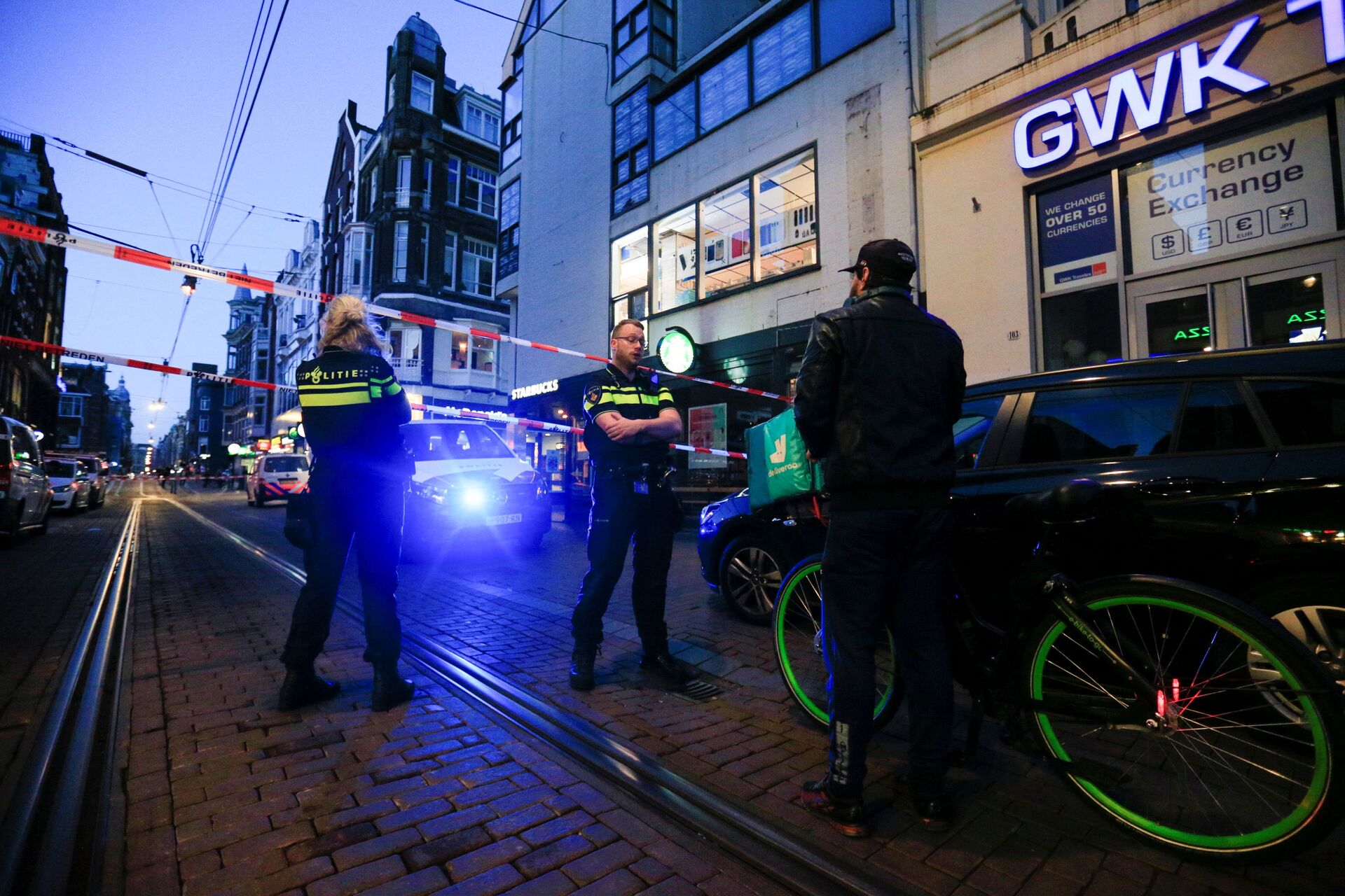Police officers talk to a person as they stand guard in the area where Dutch celebrity crime reporter Peter R. de Vries, known for his reporting on some of the most renowned criminals in the Netherlands, was reportedly shot and seriously injured, in Amsterdam, Netherlands, July 6, 2021 - Sputnik International, 1920, 07.09.2021