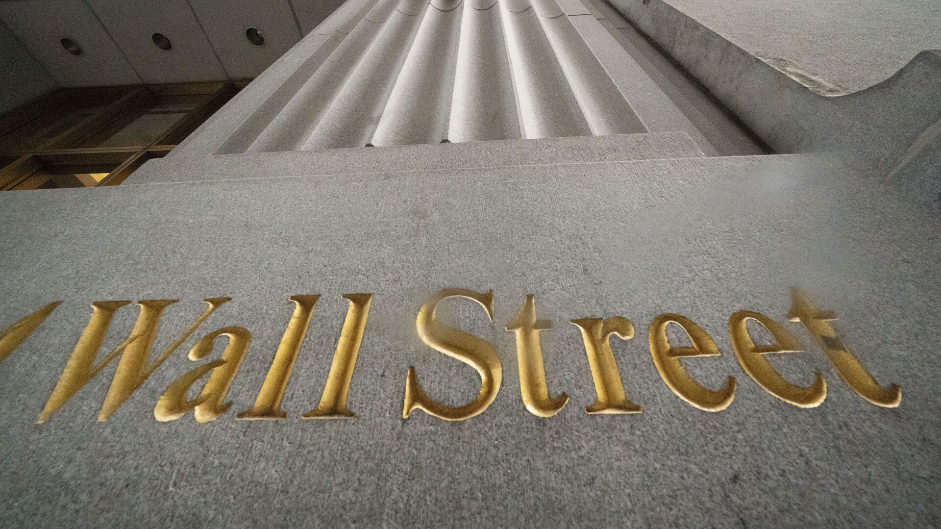 n this Nov. 5, 2020 file photo, a sign for Wall Street is carved in the side of a building. Stocks are easing lower in early trading on Wall Street, pulling major indexes slightly below the record highs they reached last week. - Sputnik International, 1920, 02.10.2021