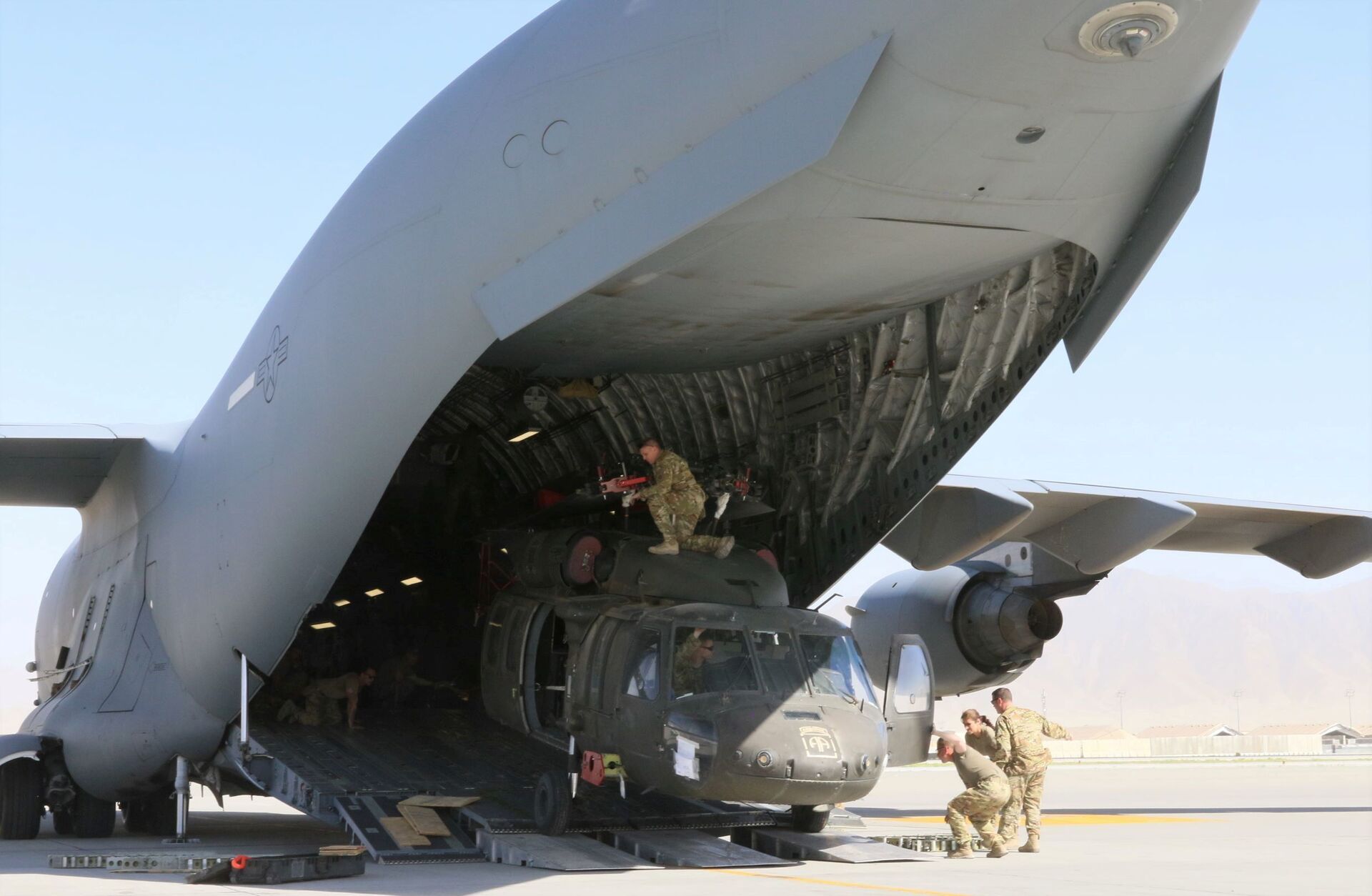 Aerial porters work with maintainers to load a UH-60L Blackhawk helicopter into a U.S. Air Force C-17 Globemaster III during the withdrawl of American forces in Afghanistan, June 16, 2021. Picture taken June 16, 2021 - Sputnik International, 1920, 07.09.2021