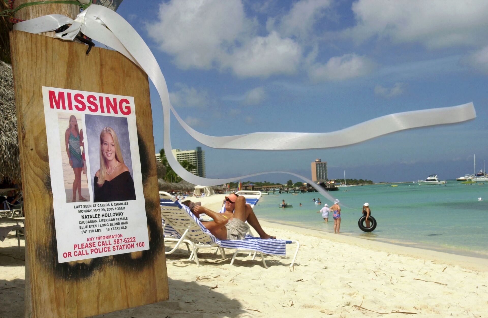 This June 10, 2005 file photo shows a missing poster for Natalee Holloway, a high school graduate of Mountain Brook, Alabama who disappeared while on a graduation trip to Aruba on May 30, 2005, on Palm Beach where tourists sunbathe in Aruba. - Sputnik International, 1920, 07.09.2021