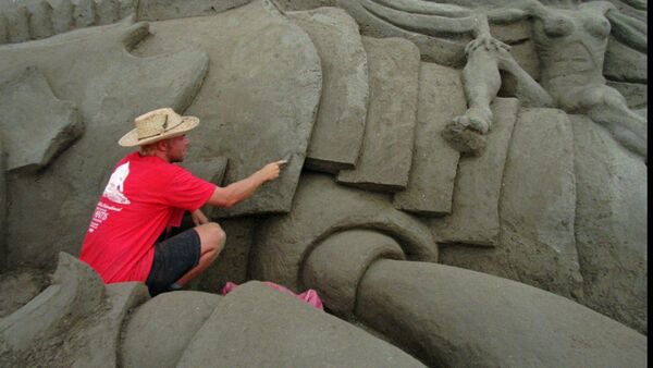 Wilfred Stijger, a sand sculptor from Holland, carves detail in a part of the The Lost City of Atlantis sand sculpture Monday Sept. 15, 1997 in San Diego - Sputnik International
