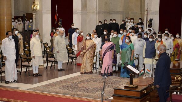 In this handout photo provided by the Indian Presidential Palace, the newly sworn in ministers, right, stand with Indian Prime Minister Narendra Modi, third left in front row, and other senior ministers during swearing in ceremony at the Presidential Palace in New Delhi, India, Wednesday, July 7, 2021. - Sputnik International