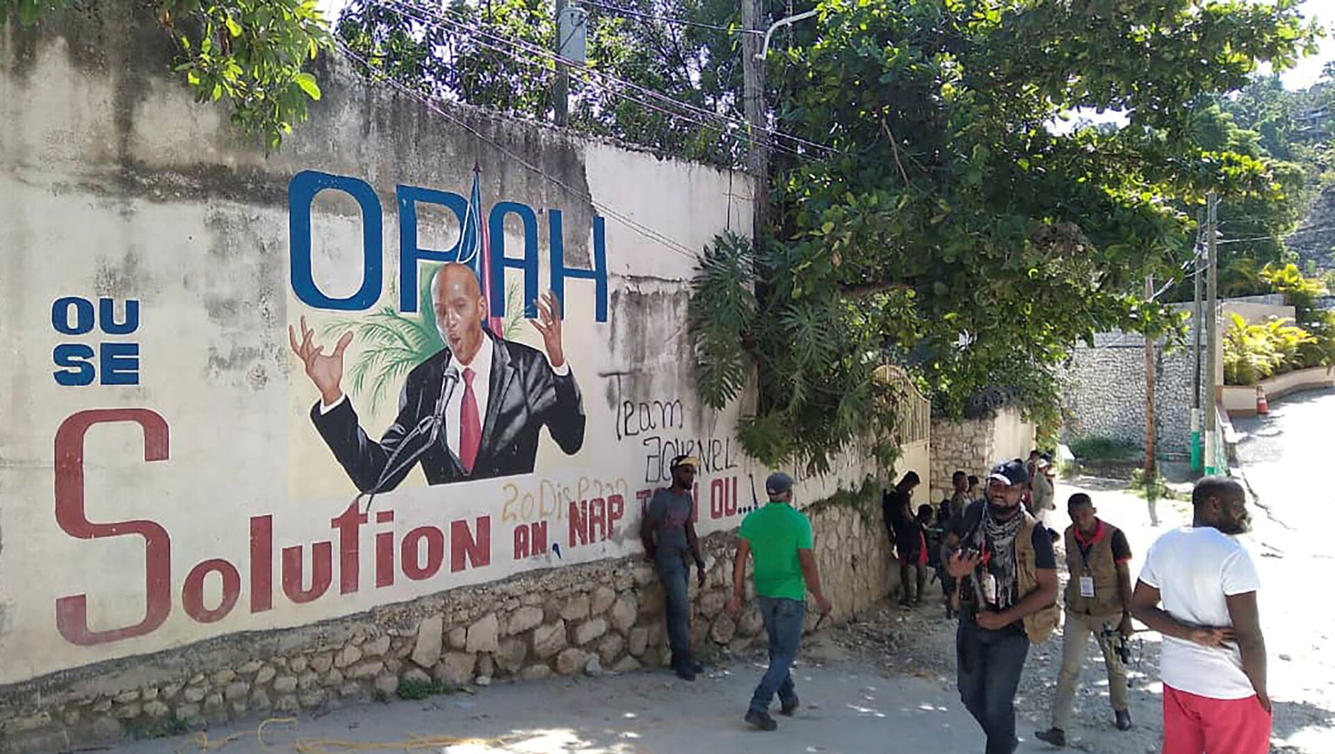 People walk past a wall with a mural depicting Haiti's President Jovenel Moise, after he was shot dead by unidentified attackers in his private residence, in Port-au-Prince, Haiti July 7, 2021.  - Sputnik International, 1920, 08.07.2021