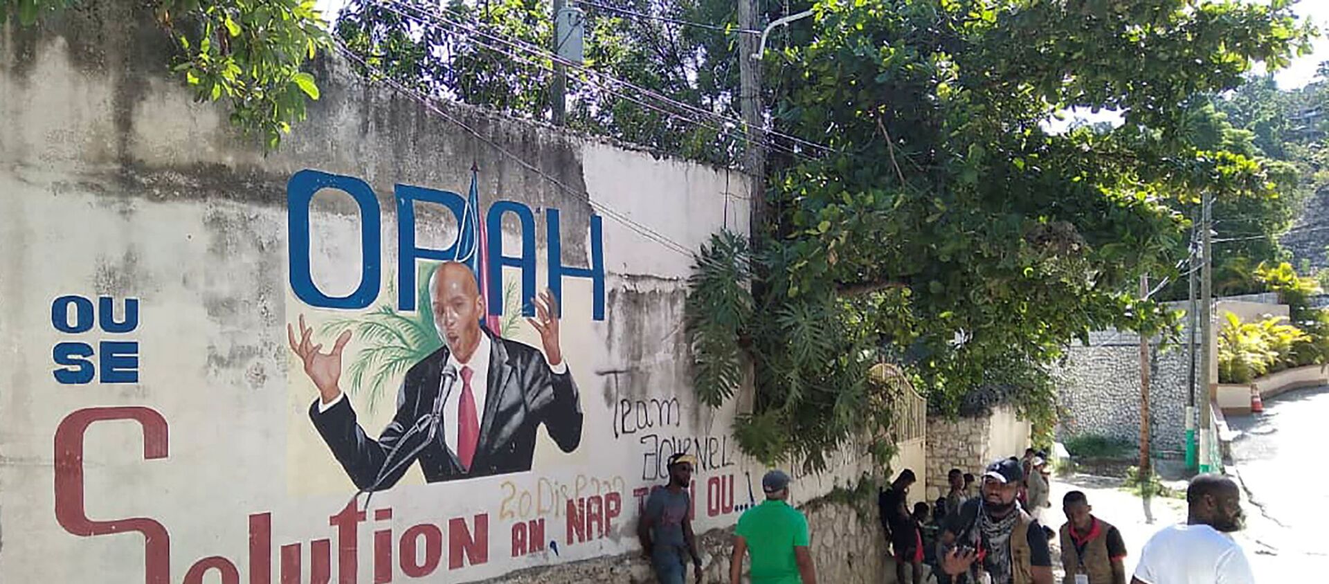 People walk past a wall with a mural depicting Haiti's President Jovenel Moise, after he was shot dead by unidentified attackers in his private residence, in Port-au-Prince, Haiti July 7, 2021.  - Sputnik International, 1920, 13.07.2021