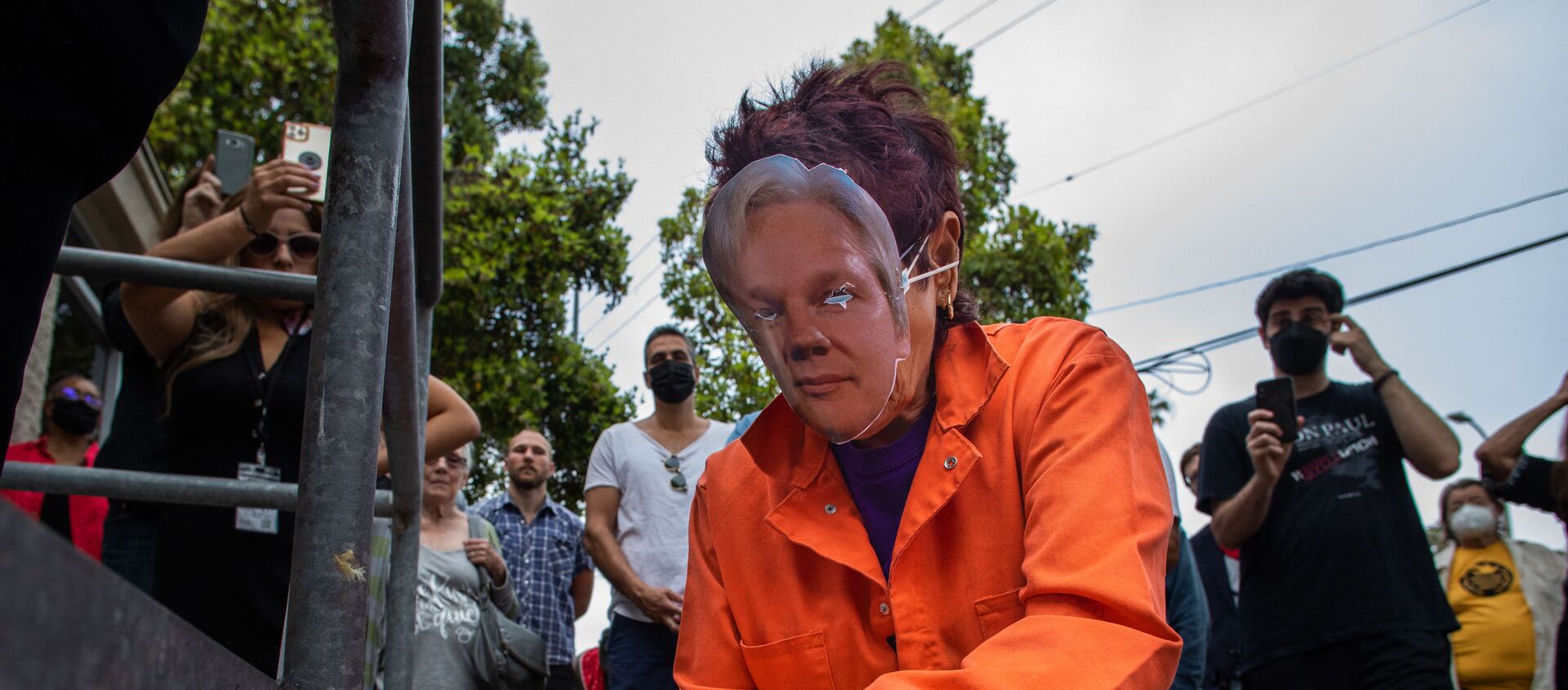 A woman wearing an orange jumpsuit and Julian Assange mask, lights a candle during a Free Julian Assange rally outside the Oakwood Community Center in Venice, Calif. on June 27, 2021, as part of a national tour to raise awareness of Assange as a threat to press freedom.  - Sputnik International, 1920, 08.07.2021