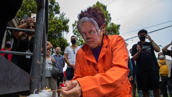 A woman wearing an orange jumpsuit and Julian Assange mask, lights a candle during a Free Julian Assange rally outside the Oakwood Community Center in Venice, Calif. on June 27, 2021, as part of a national tour to raise awareness of Assange as a threat to press freedom.  - Sputnik International