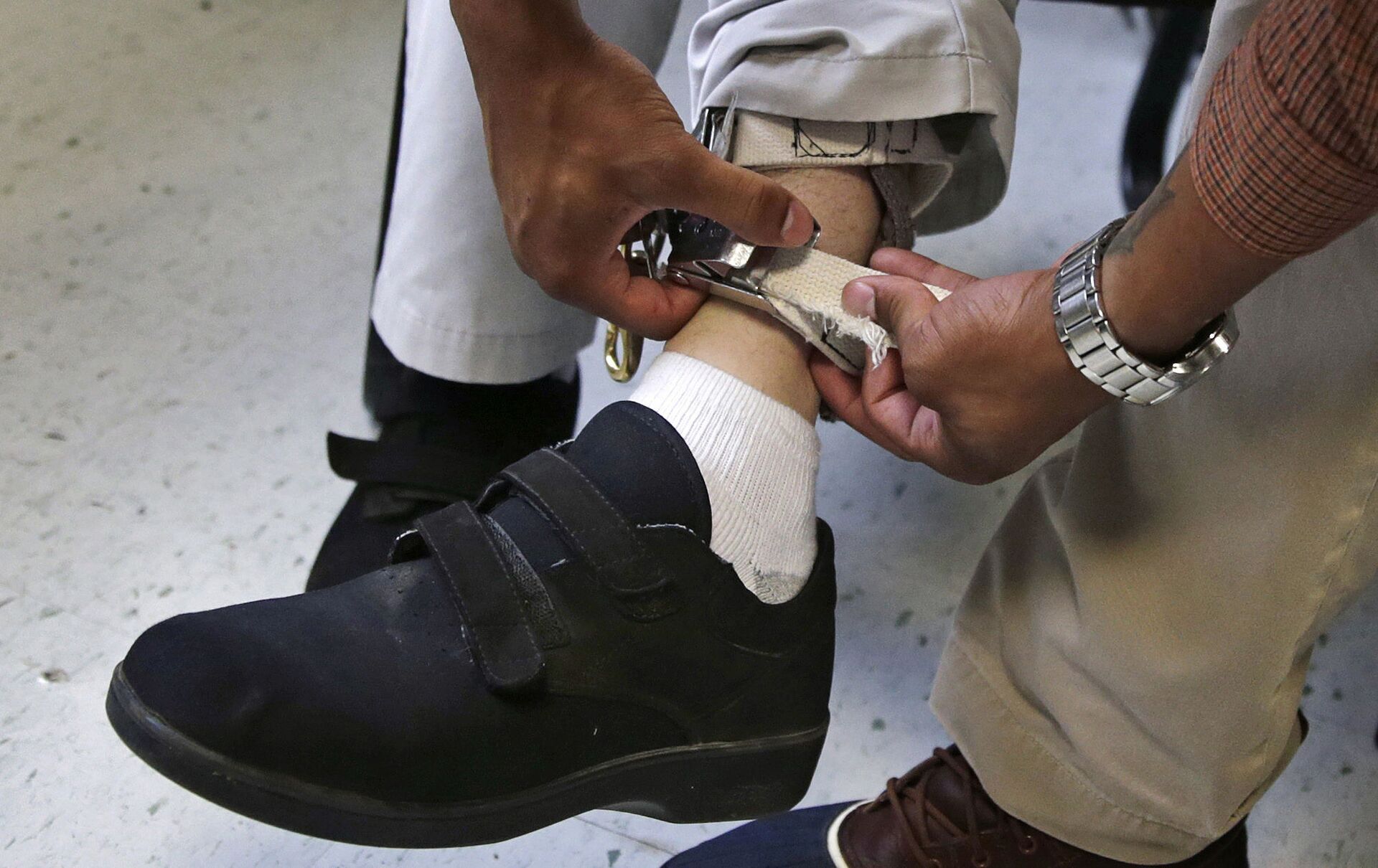In this Aug. 13, 2014 file photo, a therapist checks the ankle strap of an electrical shocking device on a student during an exercise program at the Judge Rotenberg Educational Center in Canton, Mass. The student, who was born with a developmental disorder, wears the device so administrators can control violent episodes. - Sputnik International, 1920, 07.09.2021