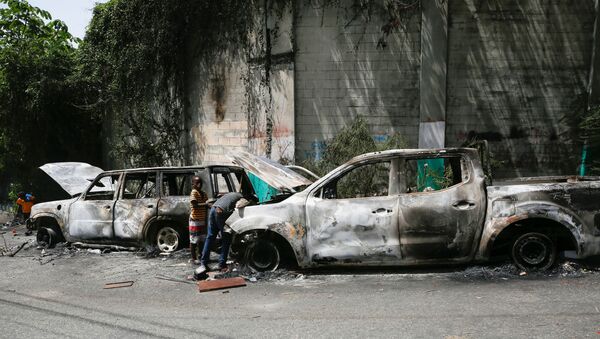 Children look for metal pieces in cars burnt by locals after a firefight between police and the suspected assassins of President Jovenel Moise who was shot dead early Wednesday at his home, in Port-au-Prince, Haiti July 8, 2021. - Sputnik International