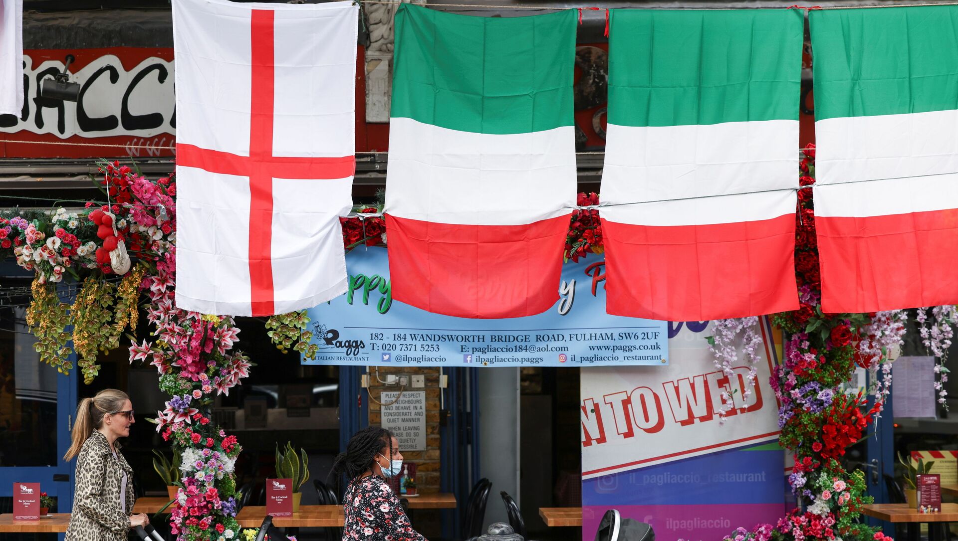 People walk past a restaurant displaying Italy and England flags, in London, Britain, 9 July 2021.  - Sputnik International, 1920, 11.07.2021